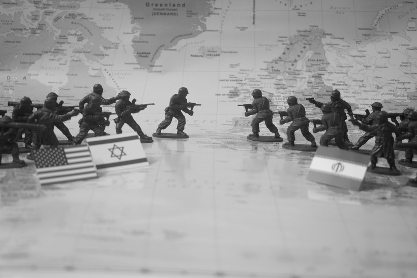 Játékkatonák világtérképen, amerikai, izraeli és iráni zászlók között szembenállva